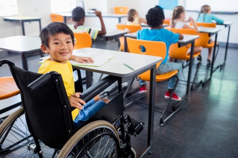 A cute people in wheel chair looking at the camera in classroom