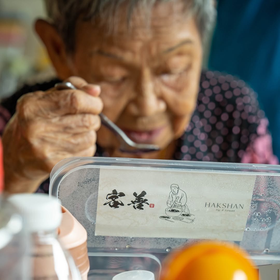 An elderly diner eating a Hakshan Hakka set meal, taken in close portrait