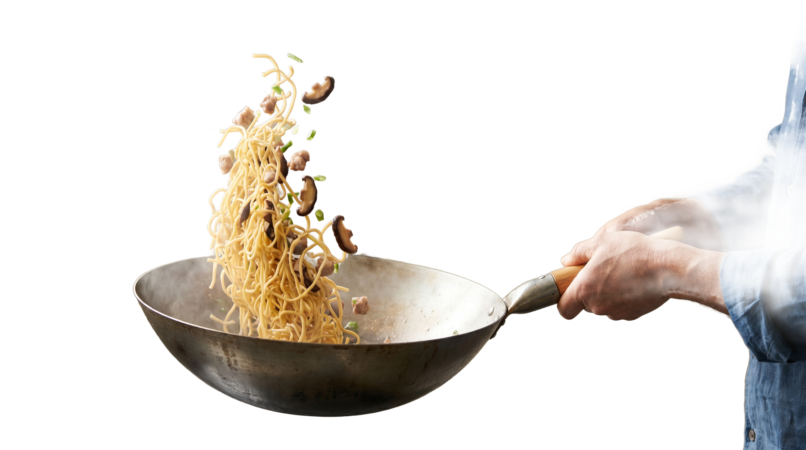 A wok caught mid-toss with stir-fried Hakka egg noodles in motion, lit by soft daylight
